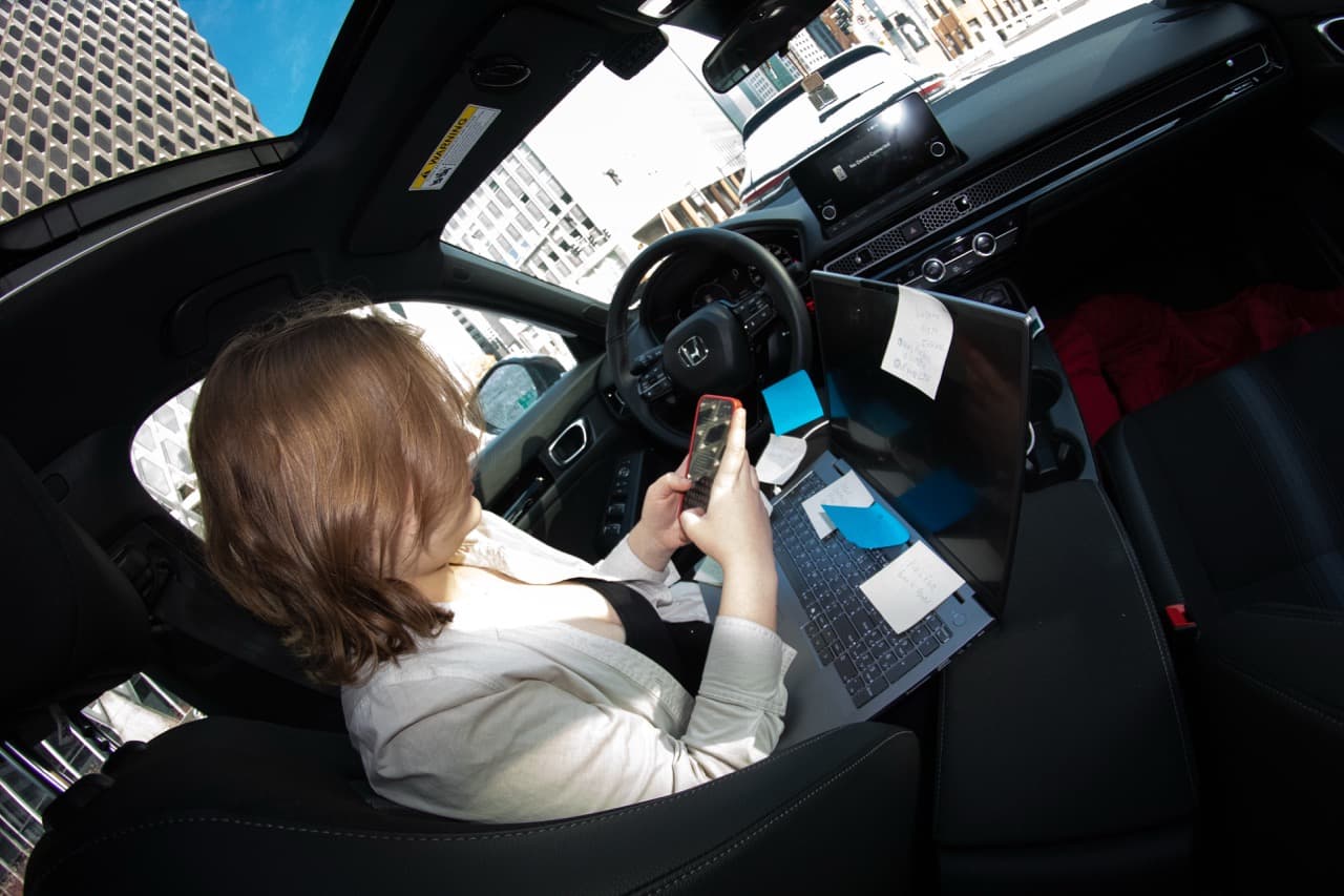 Abigail Hakas in her car, where she spends a lot of time on the commute and often works in.